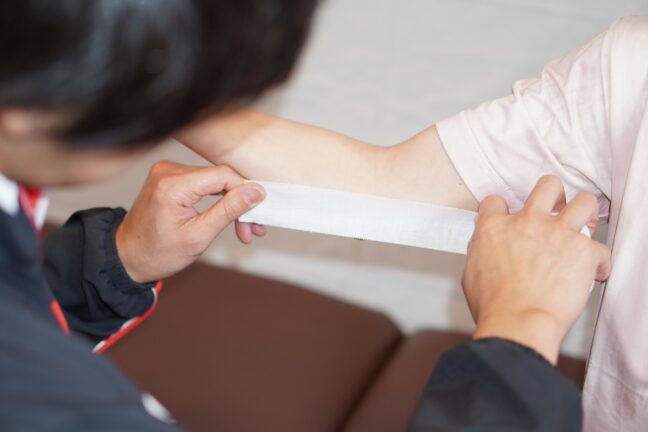 生徒の腕を診る講師